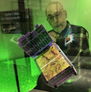 CubeStat satellite on display with person looking through display case